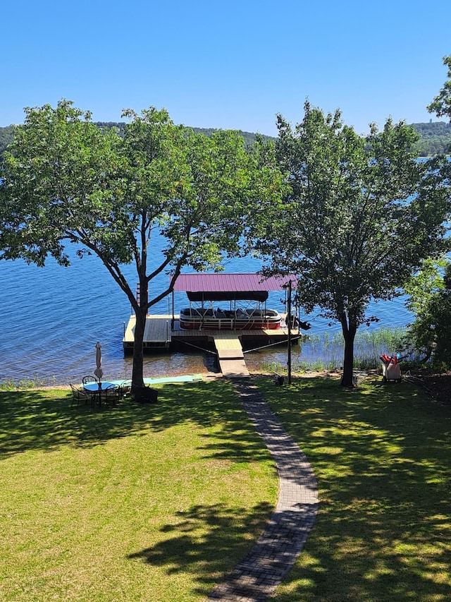 dock area with a water view and a yard