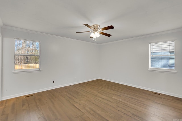 empty room with hardwood / wood-style flooring, ornamental molding, plenty of natural light, and ceiling fan