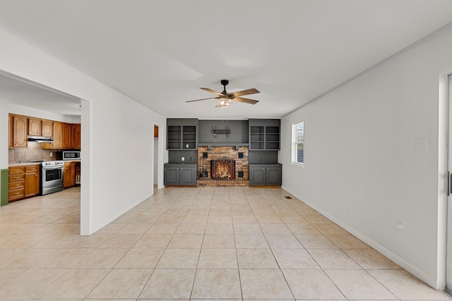 unfurnished living room featuring a fireplace, built in features, ceiling fan, and light tile patterned flooring