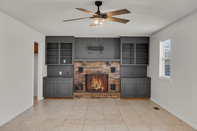 unfurnished living room featuring a brick fireplace, light tile patterned floors, and ceiling fan