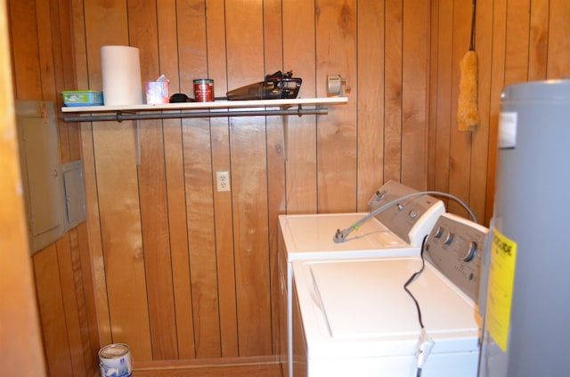 washroom with wooden walls, water heater, and washing machine and clothes dryer