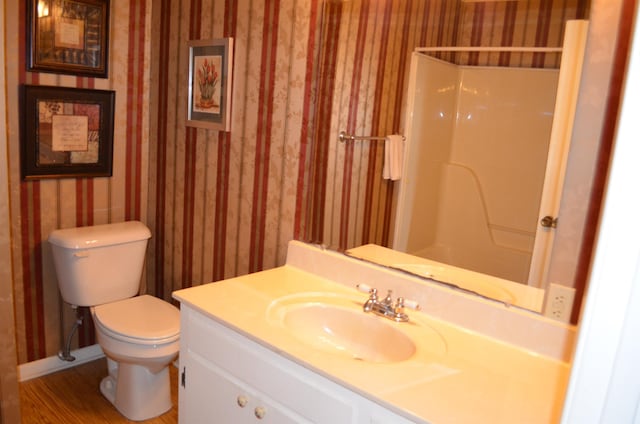 bathroom featuring vanity, toilet, hardwood / wood-style floors, and a shower