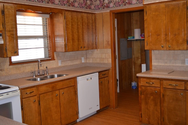 kitchen with sink, backsplash, white appliances, and light wood-type flooring