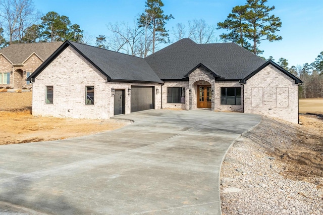 french country style house featuring a garage and french doors