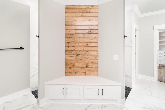 mudroom featuring ornamental molding and wood walls