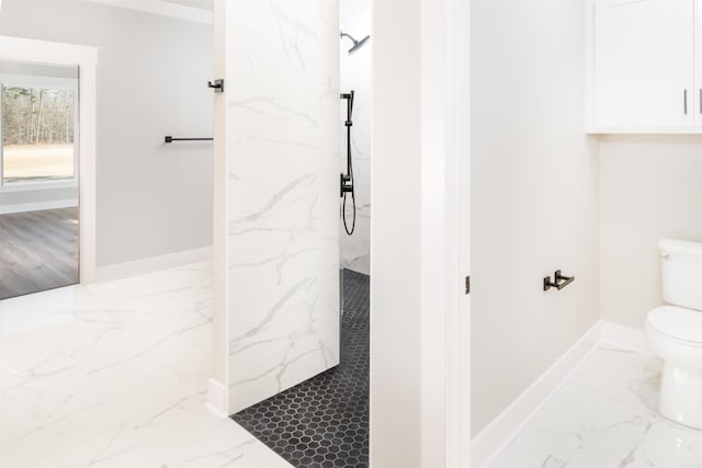 bathroom featuring toilet and a tile shower