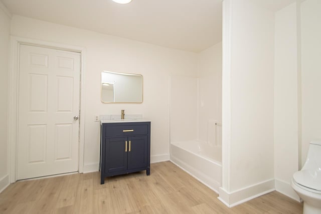 full bathroom with hardwood / wood-style flooring, shower / bathtub combination, vanity, and toilet