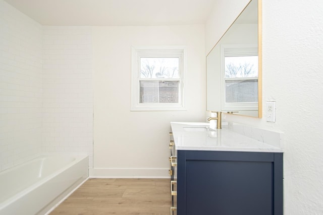 bathroom featuring tiled shower / bath combo, wood-type flooring, and vanity