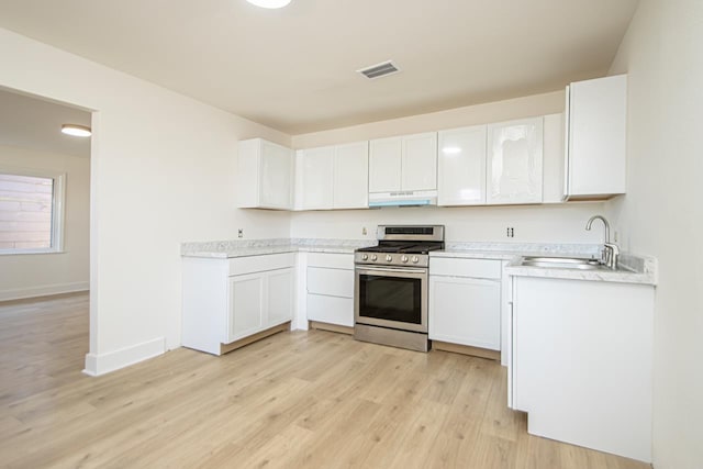 kitchen featuring white cabinetry, sink, light hardwood / wood-style floors, and stainless steel gas stove