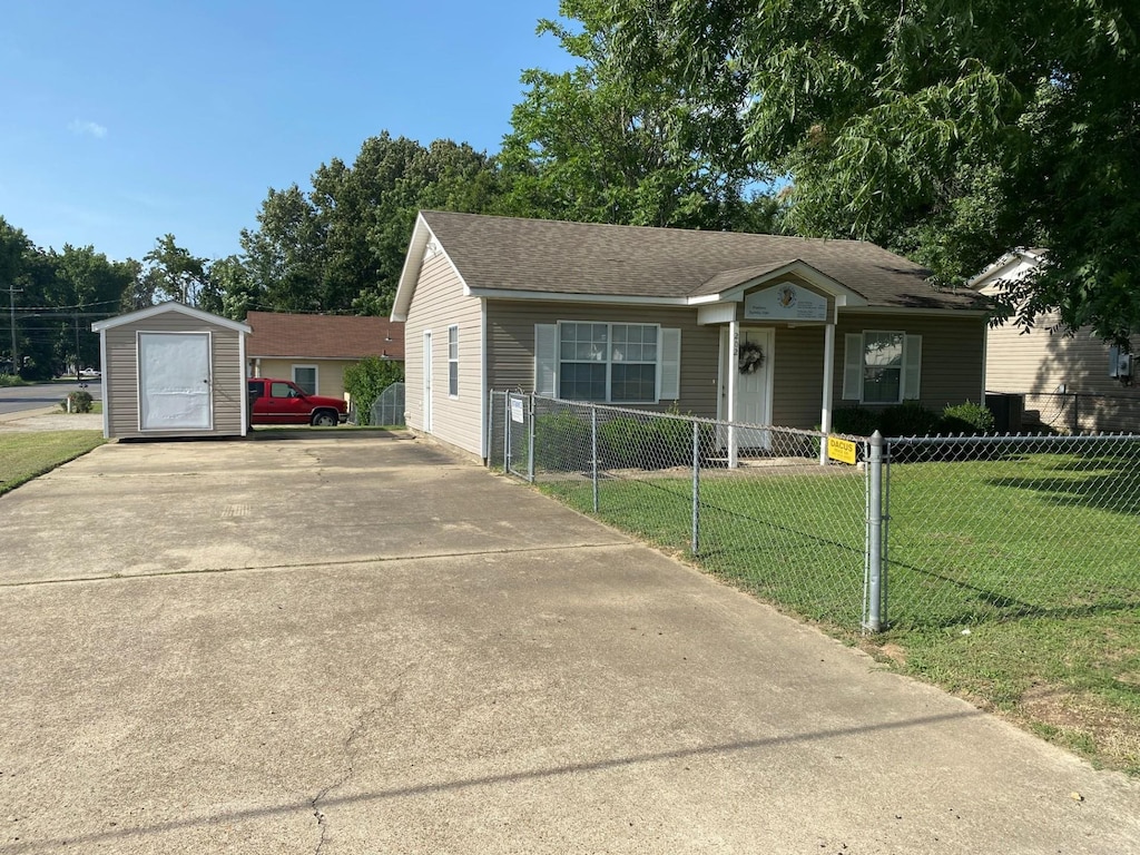 view of front of house featuring a front yard and a shed