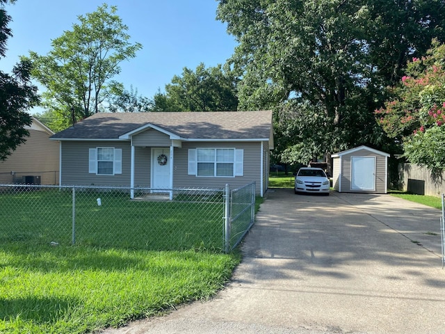 view of front of house with a storage unit and a front lawn