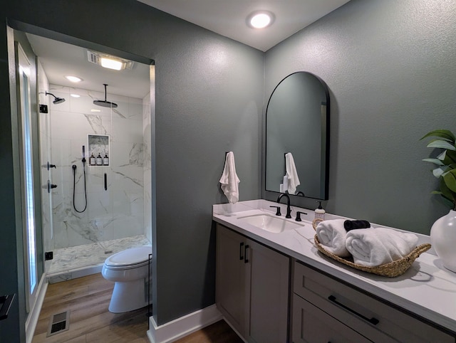 bathroom featuring vanity, hardwood / wood-style floors, toilet, and walk in shower