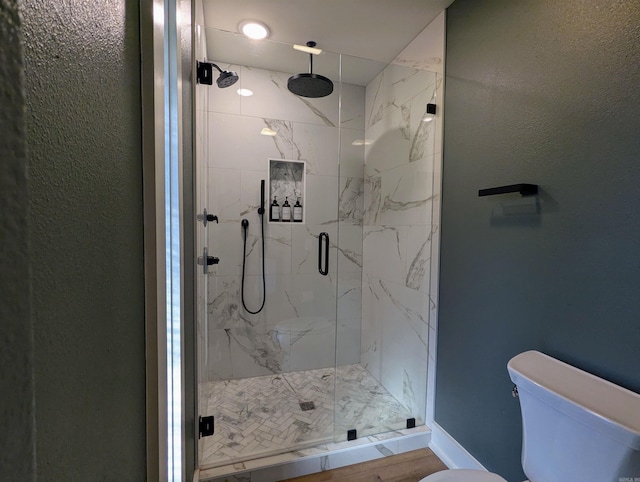 bathroom with toilet and an enclosed shower