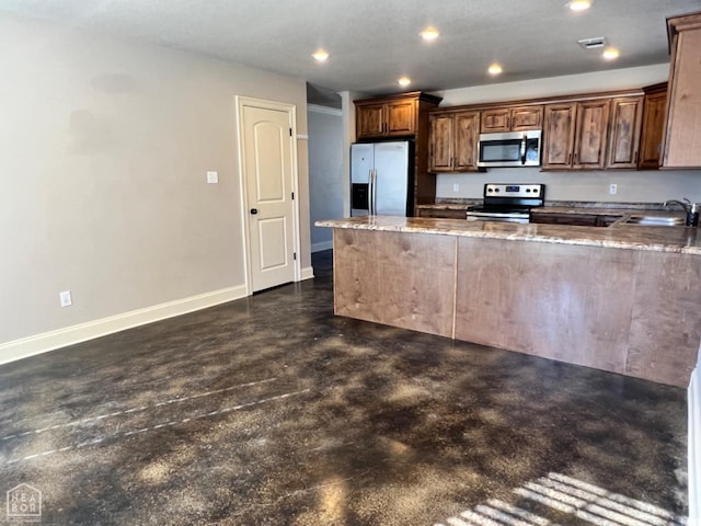 kitchen featuring light stone countertops, appliances with stainless steel finishes, sink, and kitchen peninsula