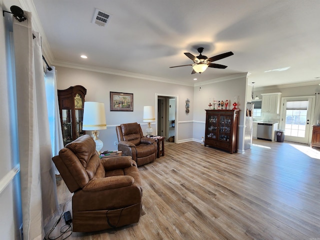 living room featuring crown molding, ceiling fan, and light hardwood / wood-style floors