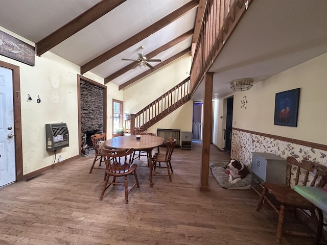 dining room featuring heating unit, hardwood / wood-style floors, a fireplace, and ceiling fan