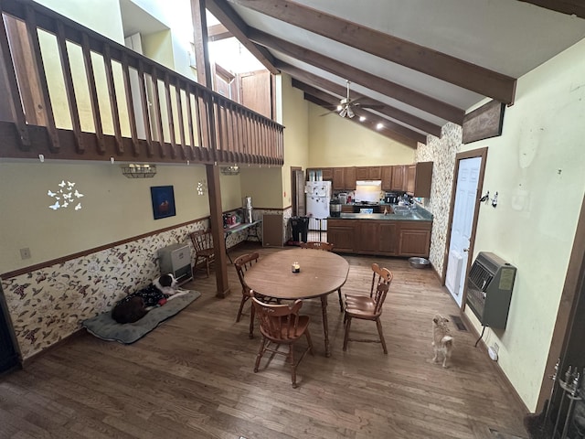 dining area with heating unit, high vaulted ceiling, wood-type flooring, ceiling fan, and beam ceiling