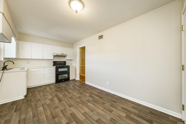 kitchen with dark hardwood / wood-style floors, white cabinetry, sink, double oven range, and a textured ceiling