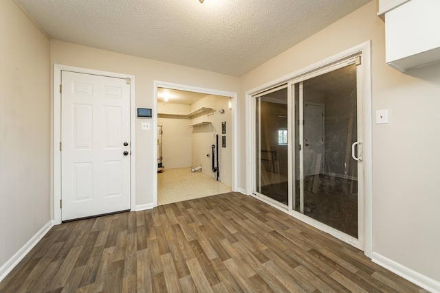 hall with dark wood-type flooring and a textured ceiling