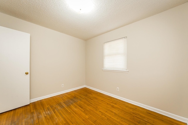 unfurnished room with hardwood / wood-style floors and a textured ceiling