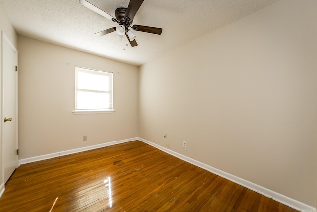 empty room with dark hardwood / wood-style flooring and a textured ceiling