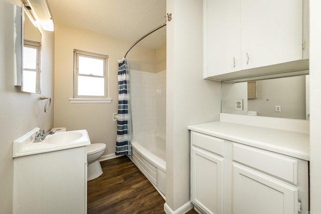 full bathroom with wood-type flooring, vanity, toilet, shower / bathtub combination with curtain, and a textured ceiling