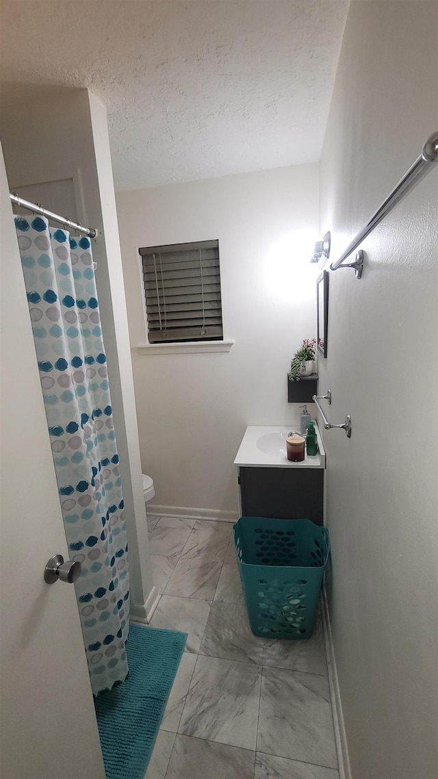 bathroom featuring vanity, toilet, and a textured ceiling