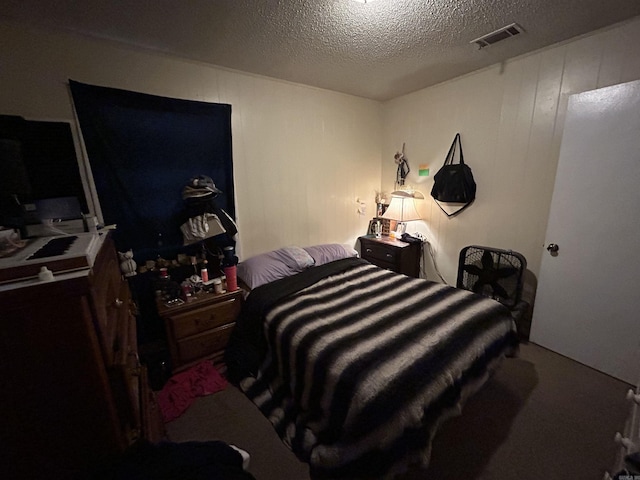 bedroom with a textured ceiling and wood walls