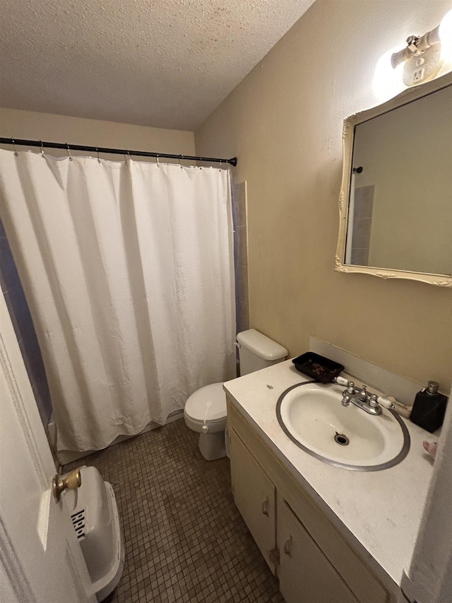 bathroom with vanity, toilet, tile patterned floors, a textured ceiling, and a shower with curtain