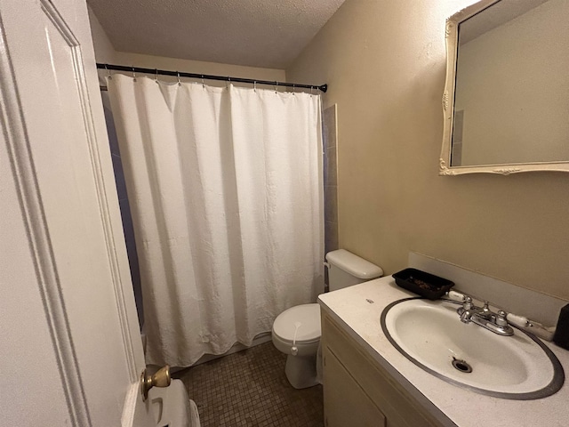 bathroom with vanity, toilet, tile patterned flooring, and a textured ceiling