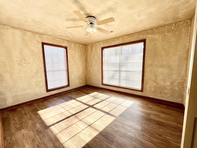 empty room with ceiling fan and dark hardwood / wood-style flooring