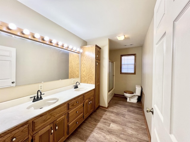 bathroom with vanity, toilet, a shower with door, and hardwood / wood-style floors