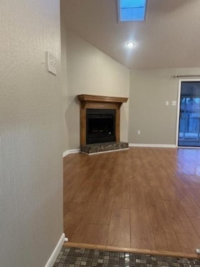 unfurnished living room featuring dark wood-type flooring and vaulted ceiling