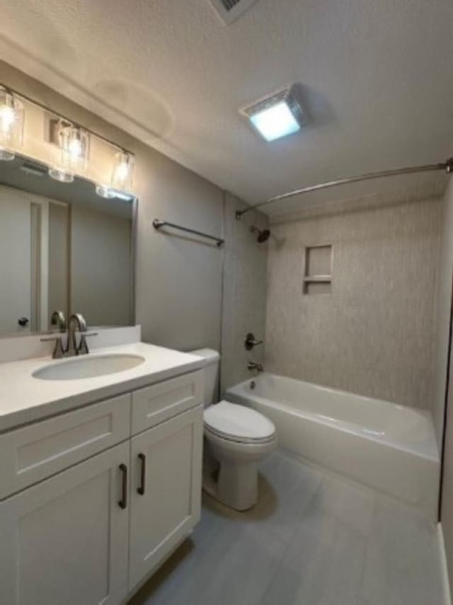 full bathroom featuring tiled shower / bath, vanity, a textured ceiling, and toilet