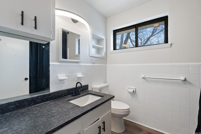 bathroom with hardwood / wood-style flooring, vanity, tile walls, and toilet