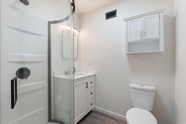 bathroom featuring vanity, hardwood / wood-style floors, a shower, and toilet