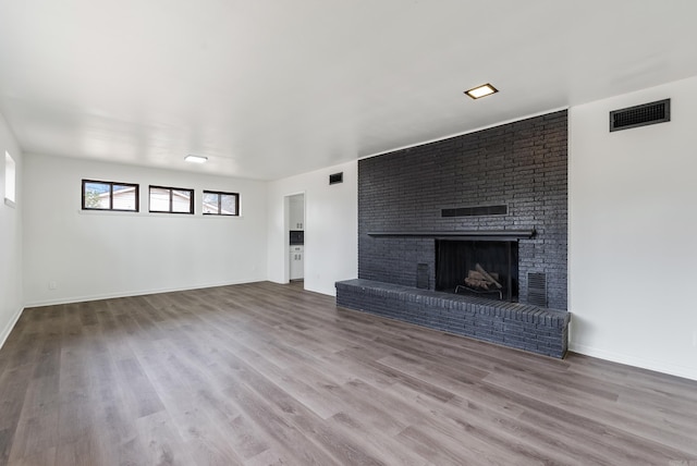 unfurnished living room featuring hardwood / wood-style flooring and a fireplace