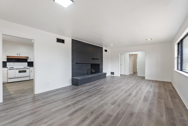 unfurnished living room featuring a fireplace and light hardwood / wood-style floors