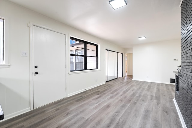 unfurnished living room with a fireplace and light hardwood / wood-style flooring