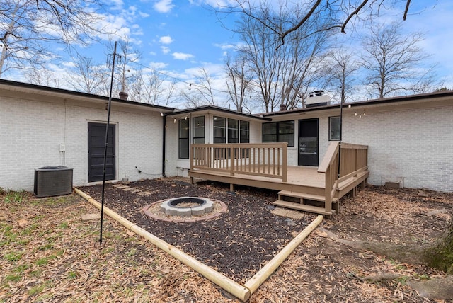 back of house featuring a wooden deck, cooling unit, and an outdoor fire pit