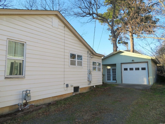 view of side of home with an outbuilding, a garage, and french doors