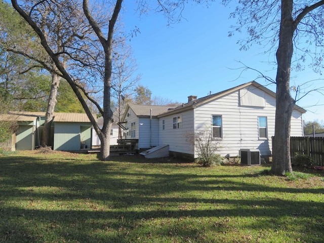 back of property featuring cooling unit, a lawn, and a deck