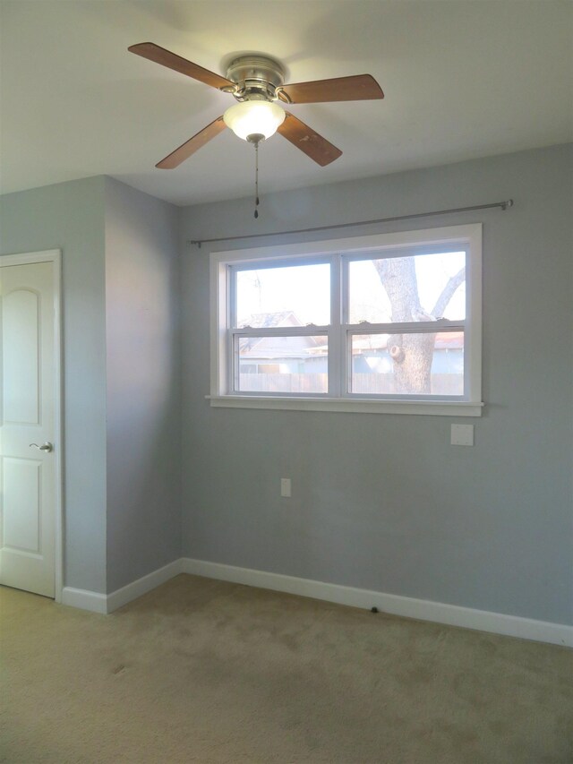 carpeted spare room featuring ceiling fan