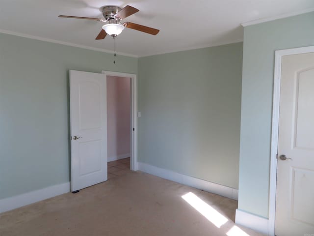 spare room with crown molding, ceiling fan, and light carpet