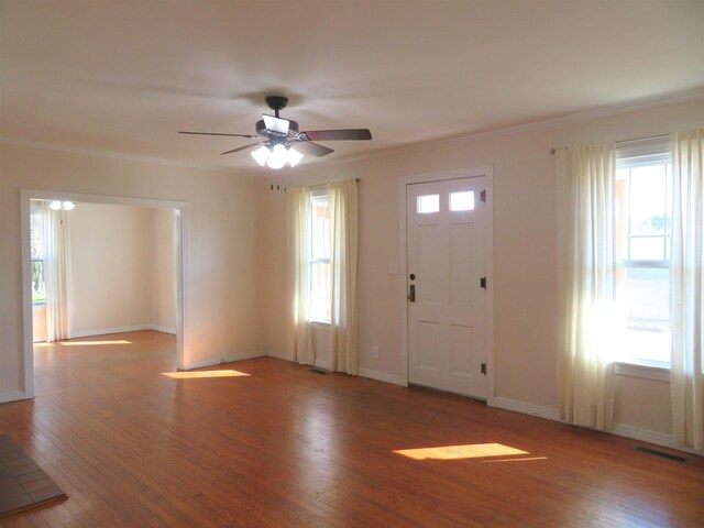 entryway with crown molding, a wealth of natural light, ceiling fan, and light hardwood / wood-style flooring