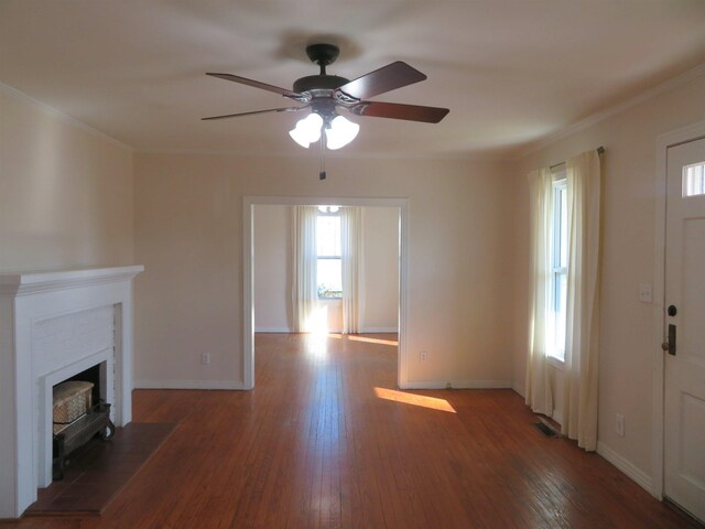 unfurnished living room with crown molding, dark hardwood / wood-style floors, and ceiling fan