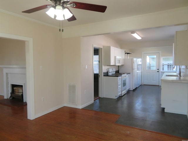 kitchen with white appliances, dark hardwood / wood-style floors, sink, and white cabinets