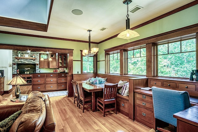 dining space featuring crown molding, a healthy amount of sunlight, and light hardwood / wood-style flooring