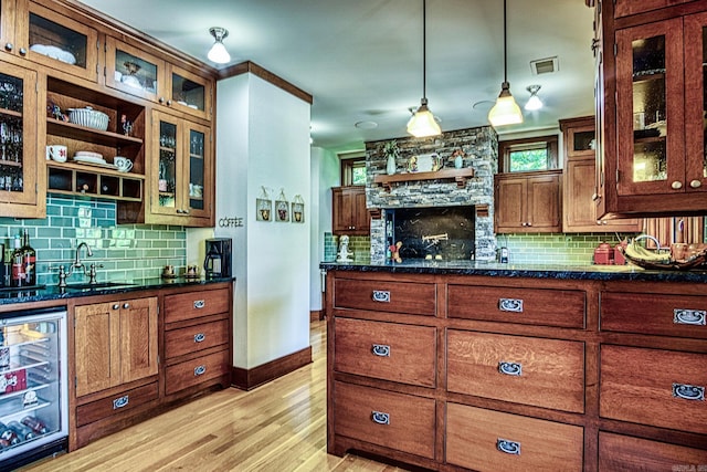 kitchen with wine cooler, sink, hanging light fixtures, light hardwood / wood-style floors, and decorative backsplash