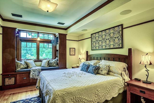 bedroom featuring hardwood / wood-style floors and ornate columns